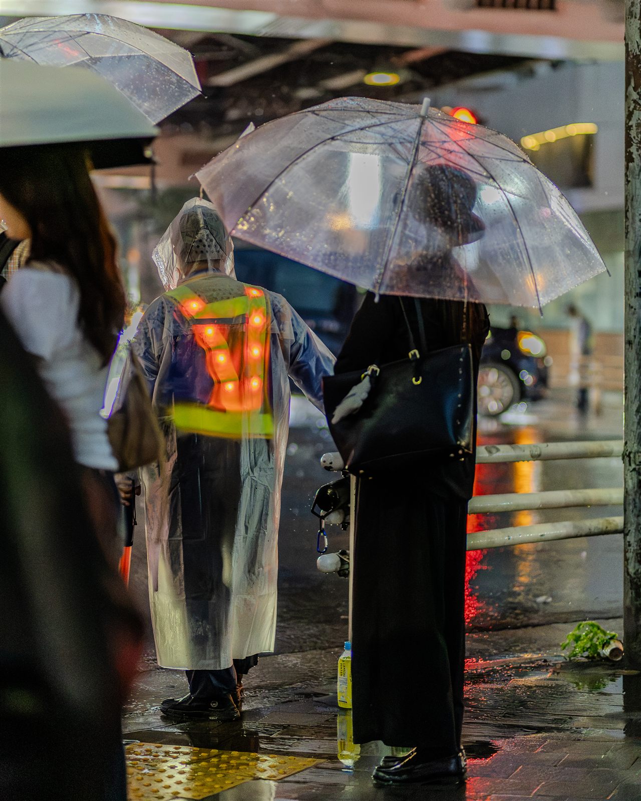 傘をさして雨の麻布十番を歩く参加者