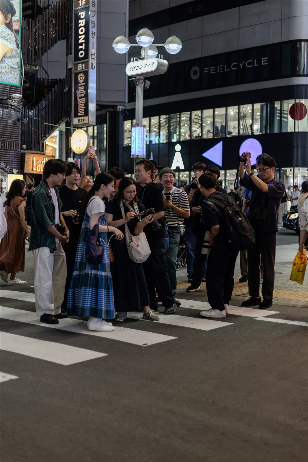夜のスクランブル交差点で撮影する参加者