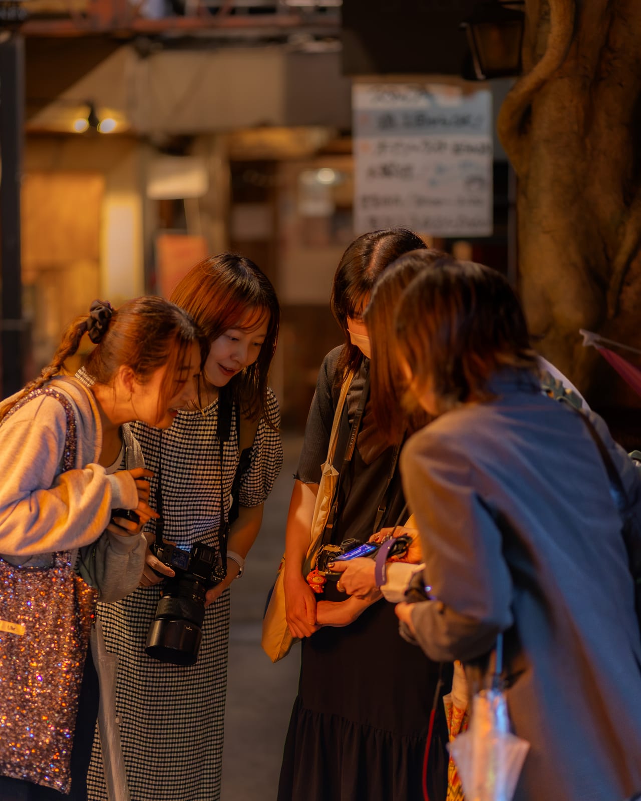 夜の路地で撮った写真を見せ合う参加者たち