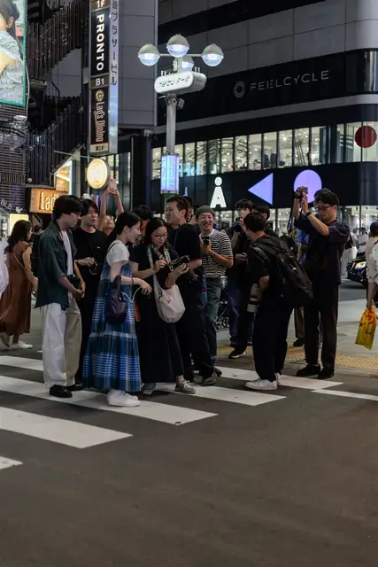 夜のスクランブル交差点で撮影する参加者